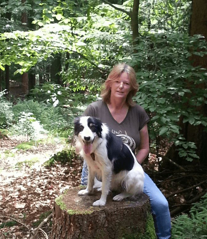 Dorothee Roland-Gelhausen mit einem Border Collie im Wald